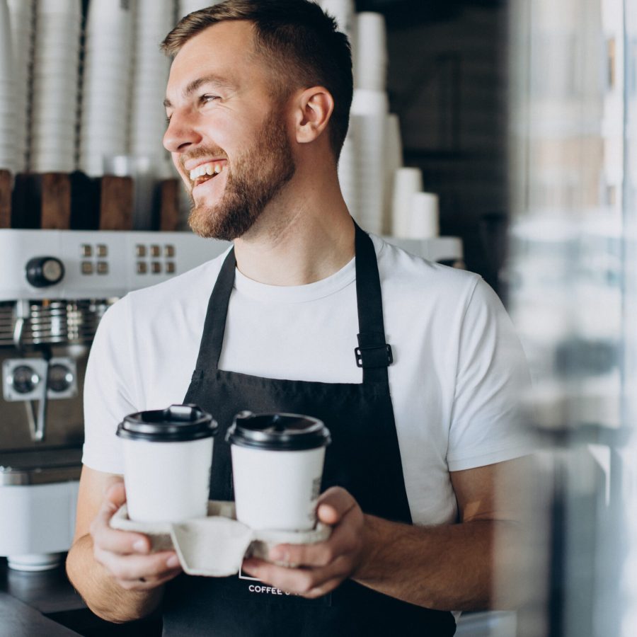 Male barista with take away coffee Male barista with take away coffee